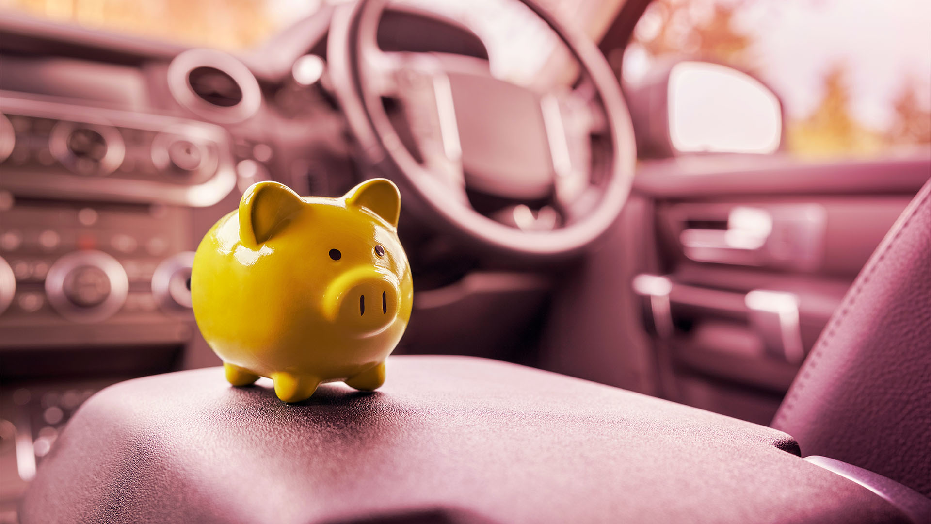 porquinho amarelo de vidro em um banco de um carro